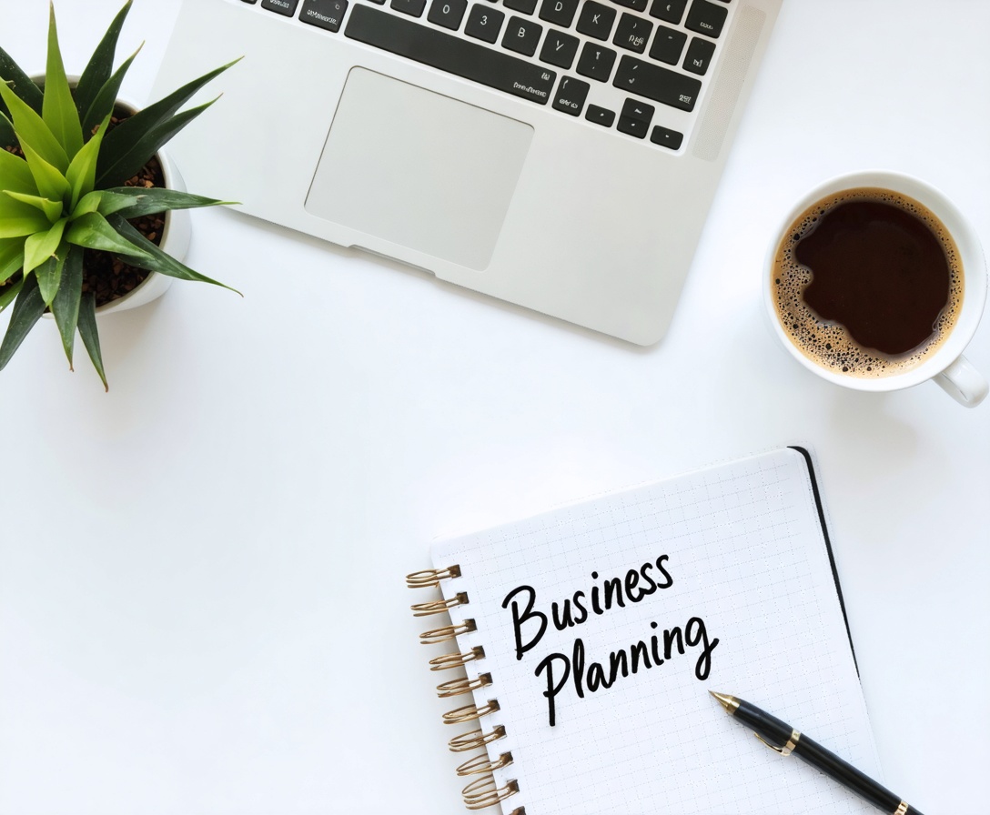 Čistý pracovný priestor s laptopom a zápisníkom s ručným písmom